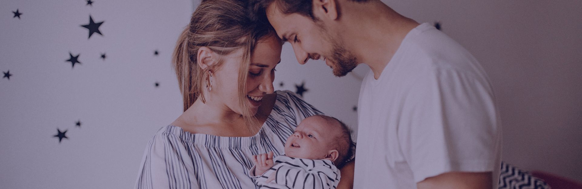 para trzymająca niemowlę w dziecięcym pokoju